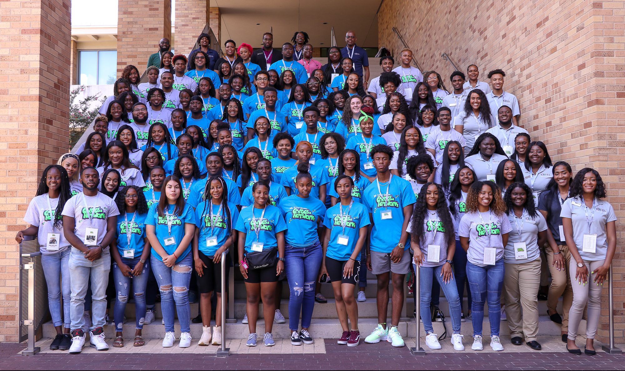 ExCEL Group Photo Image of ExCEL students posing in front of a sign that reads "Texas A&M"