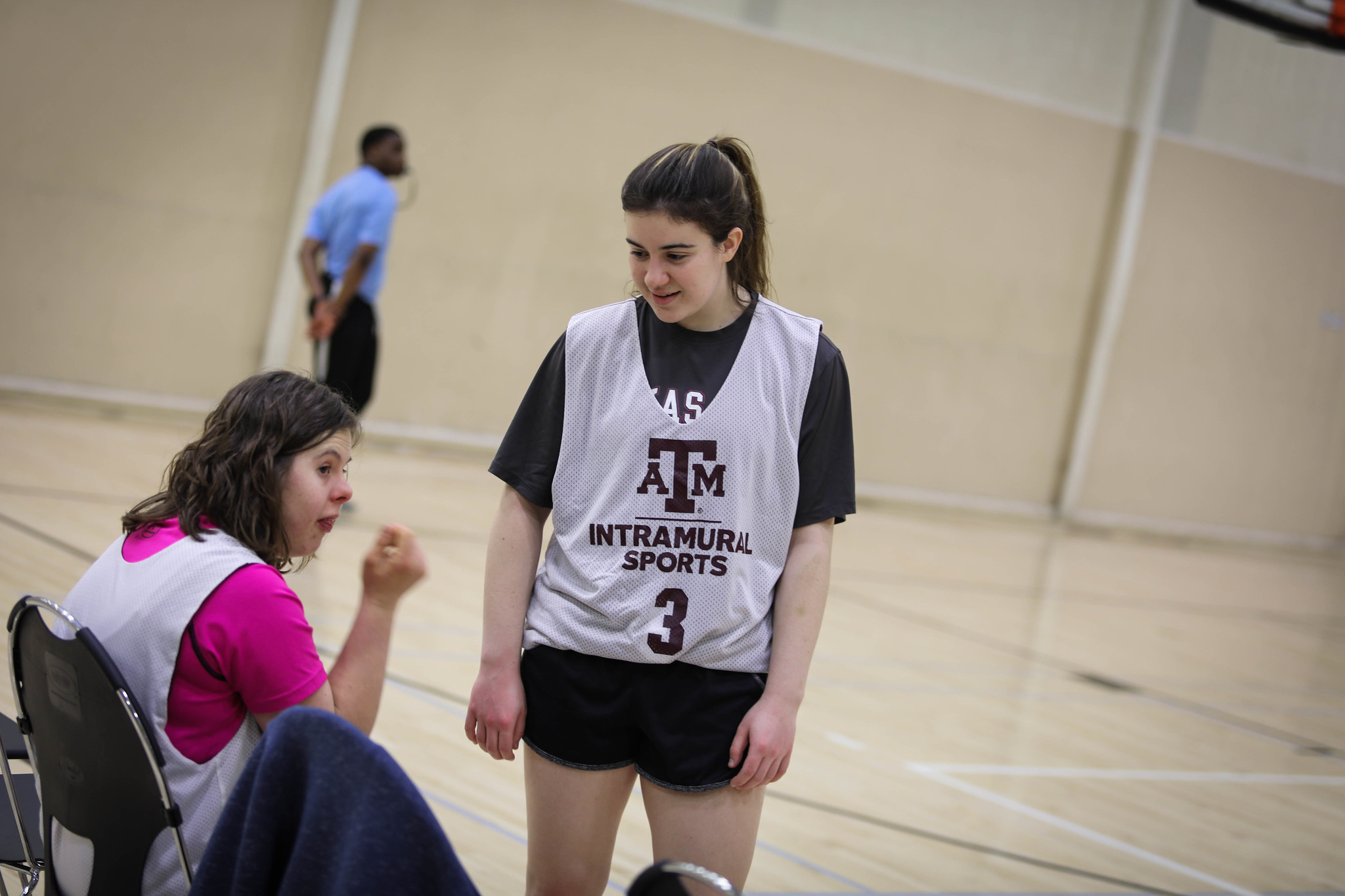 Two female students playing intramural basketball