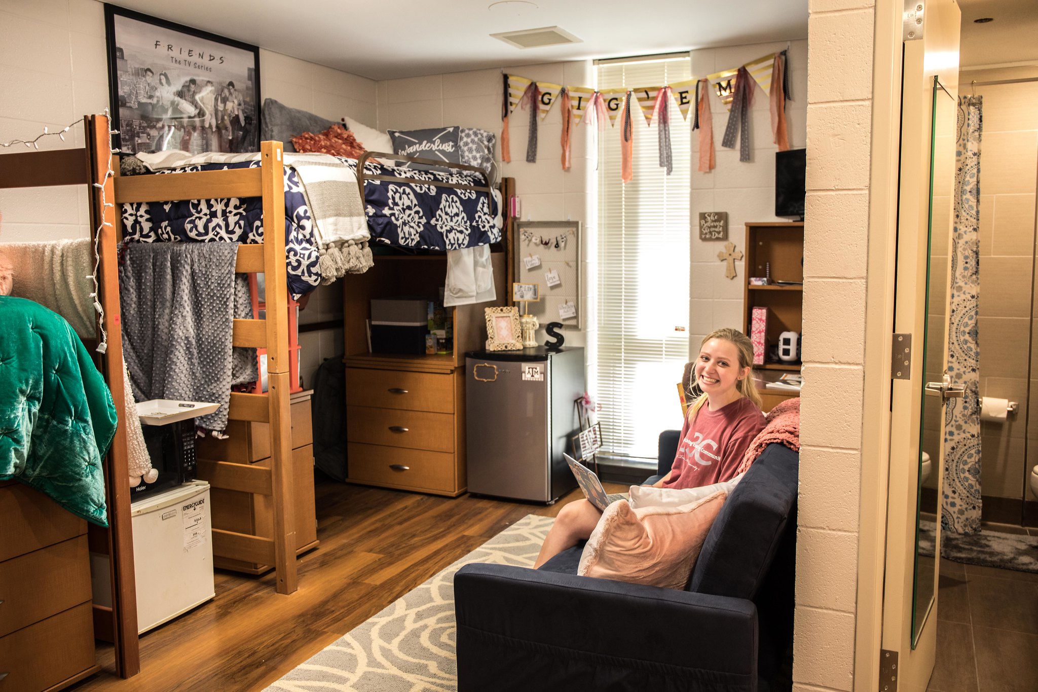 Image of a female student inside of a dorm room. 