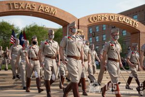 Image of the Corps of Cadets marching off the Corps quad with the iconic Quad arches behind them.