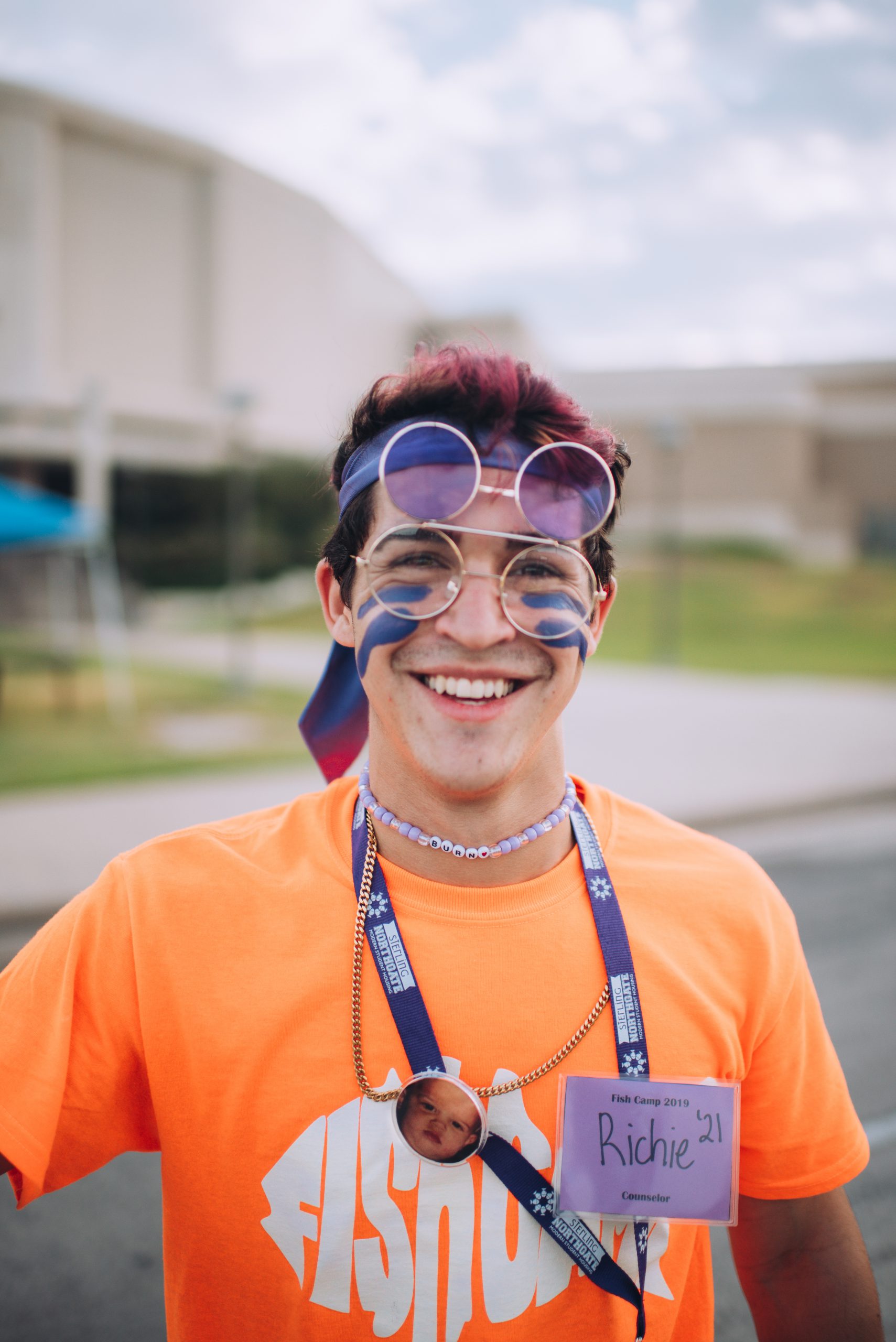 Image of student at Fish Camp smiling while wearing sunglasses and face paint.