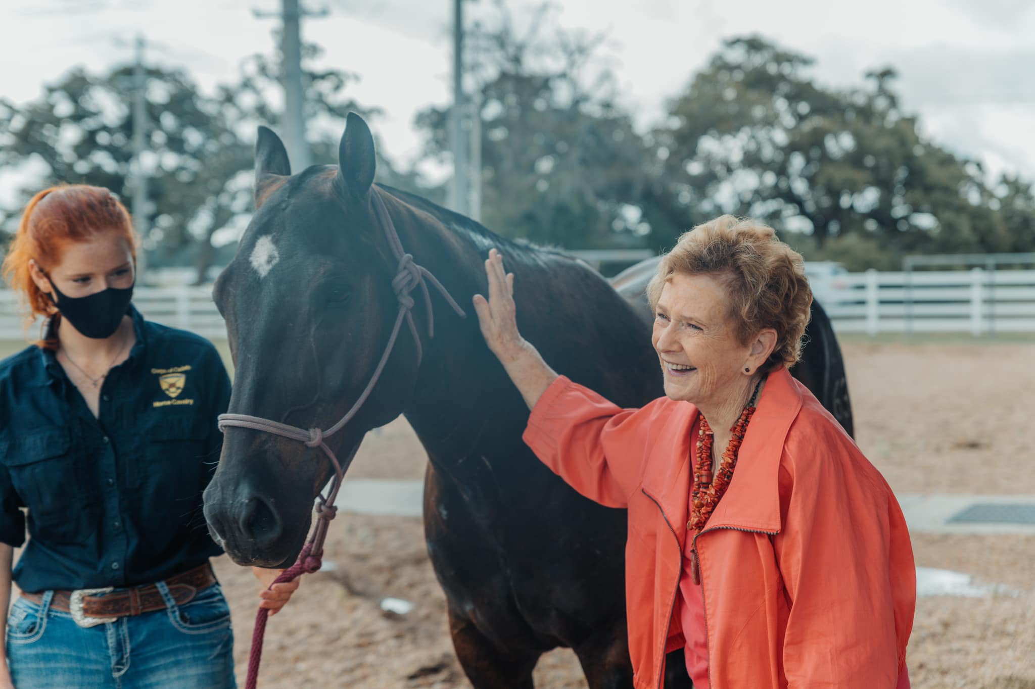 Image of Dorothy McFerrin standing next to the horse she sponsored at the Parson's Mounted Cavalry arena.