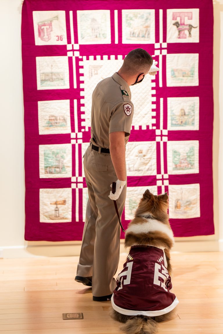 Image of Reveille and her handler admiring and appreciating a piece of art at the University Art Galleries