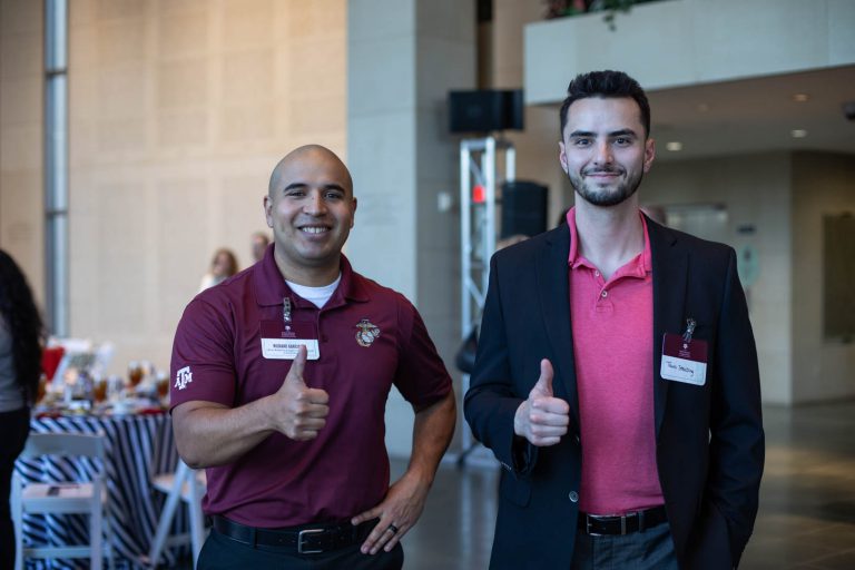 Image of veterans resource & support center employees throwing a gig 'em sign