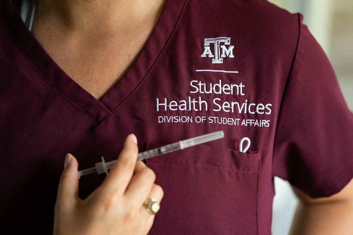 Nursing student holding vaccine syringe