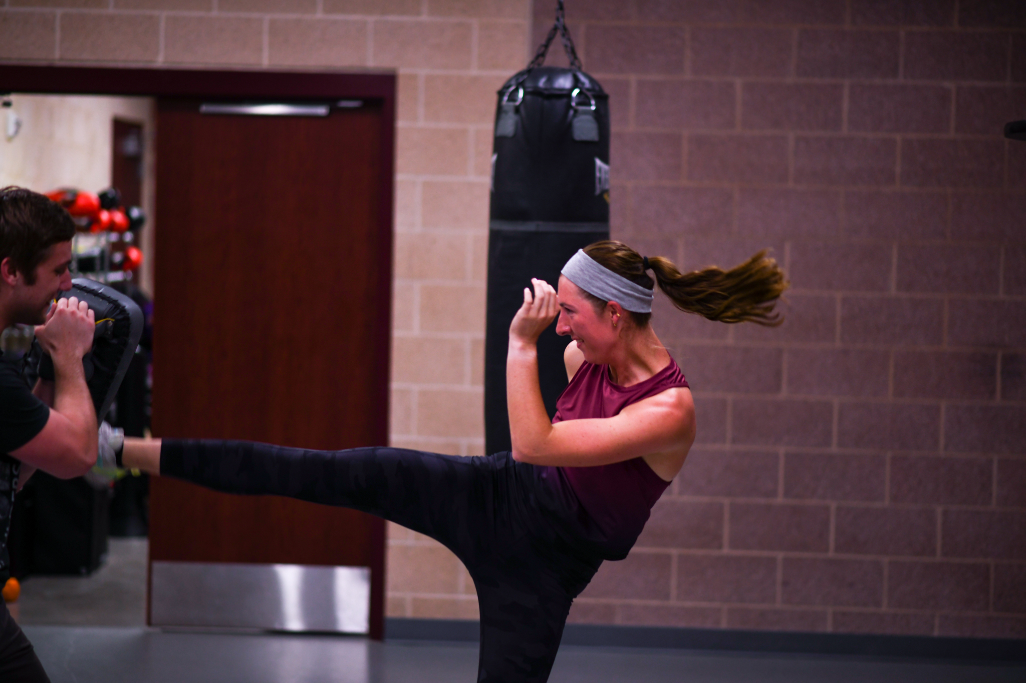 Image of a student doing a roundhouse kick during kickboxing bootcamp