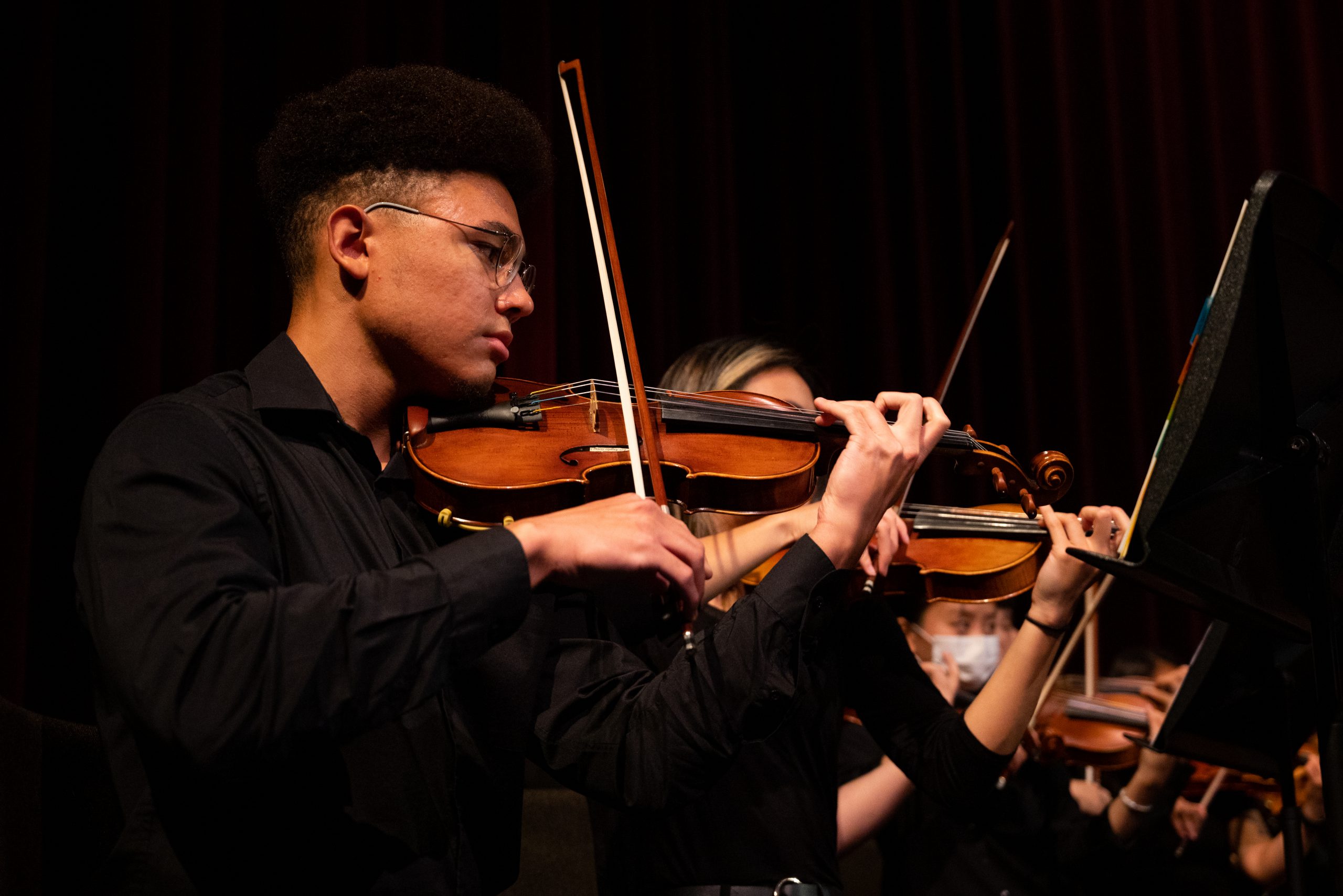 Student plays violin during an orchestra performance