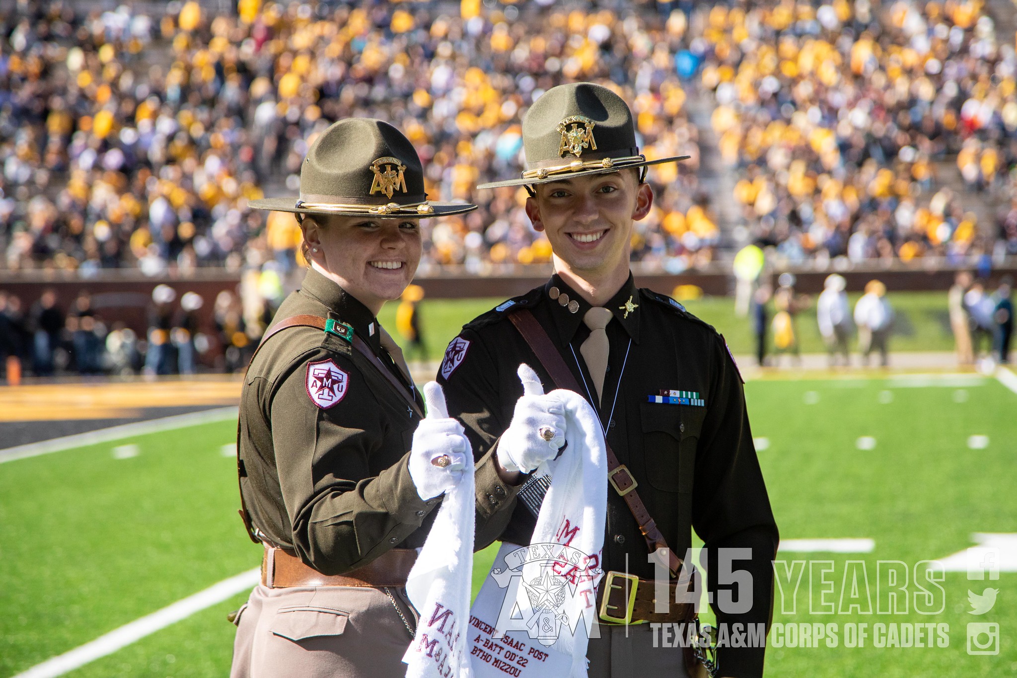 two cadets gig 'em at the football game against Missouri