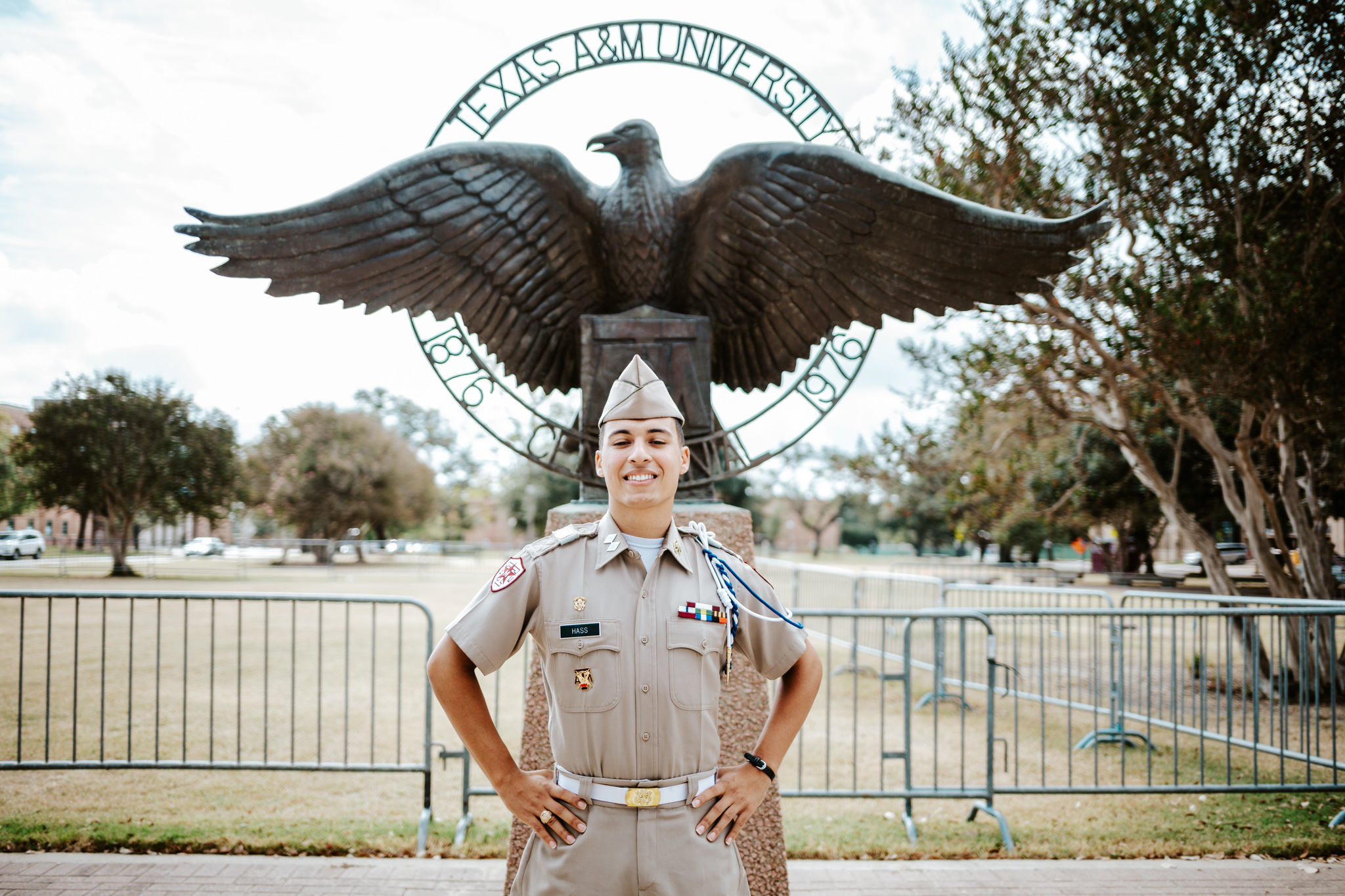 Cadet George Hass stands in front of Eagle statue on Quad in uniform.