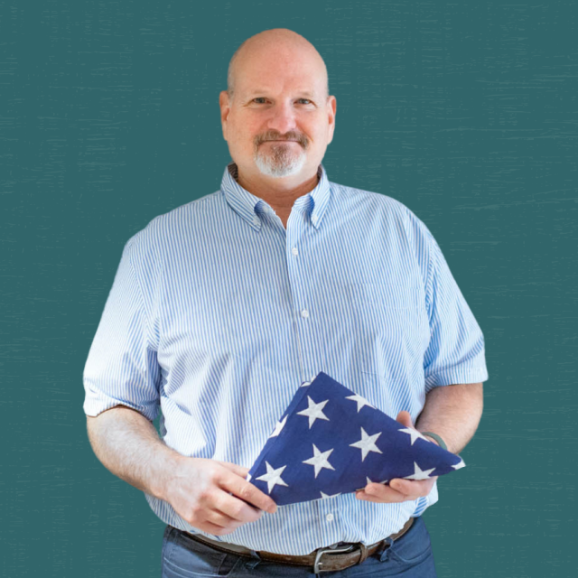 photo of Don Freeman holding an american flag