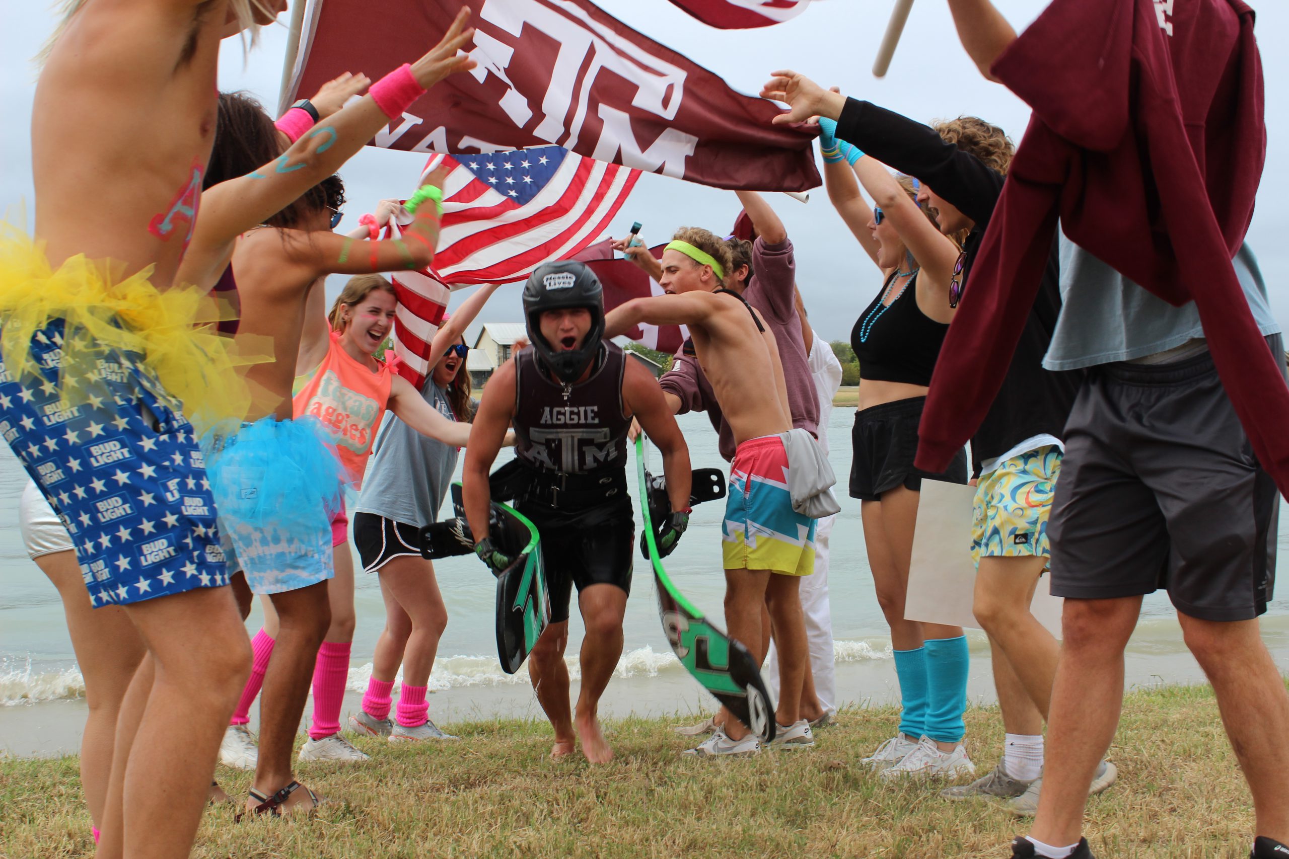 Texas A&M Water Ski club cheers and waves an A&M and US flag post national championship.