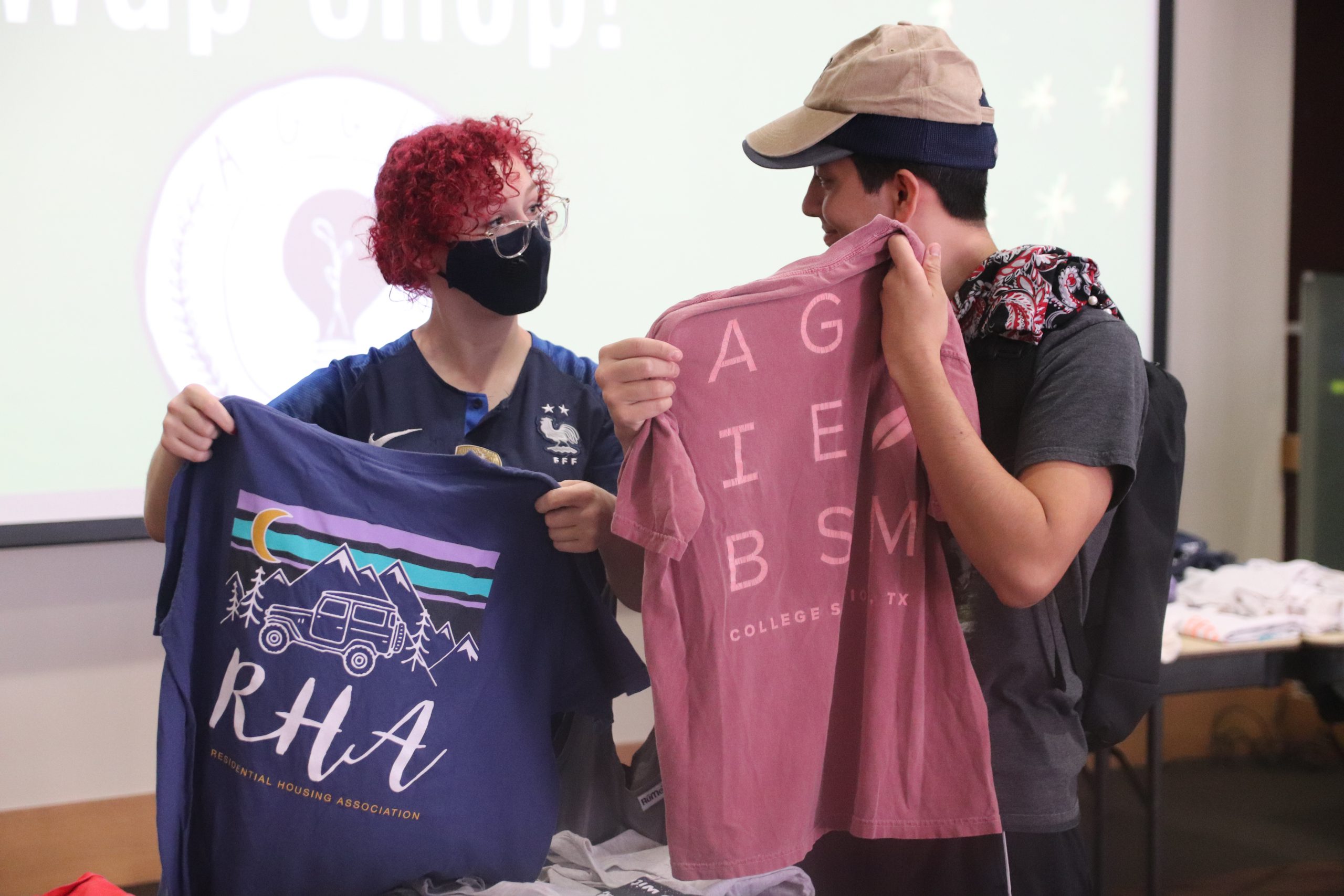 Swap Shop photo of two students holding t-shirts