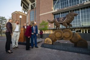 Photo of donors admiring the Reveille statue in front of Kyle Field.
