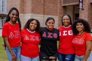 FIve Greek Life students in red shirts with Delta Sigma Theta letters