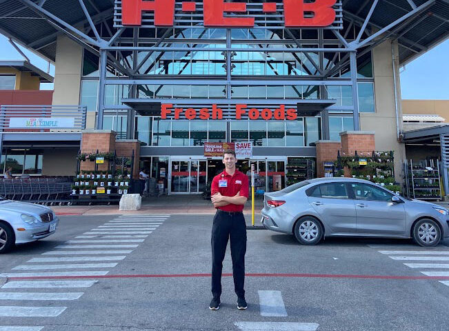 Zach Miller in front of an HEB Store during his first internship.