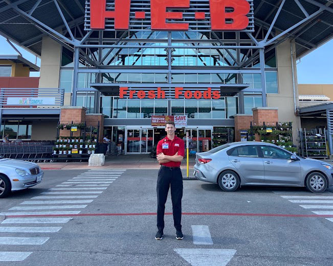 Zach Miller in front of an HEB Store during his first internship.