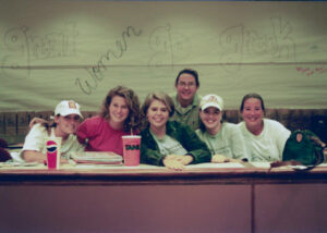 a historical photo of women in front of a "great women go greek banner"