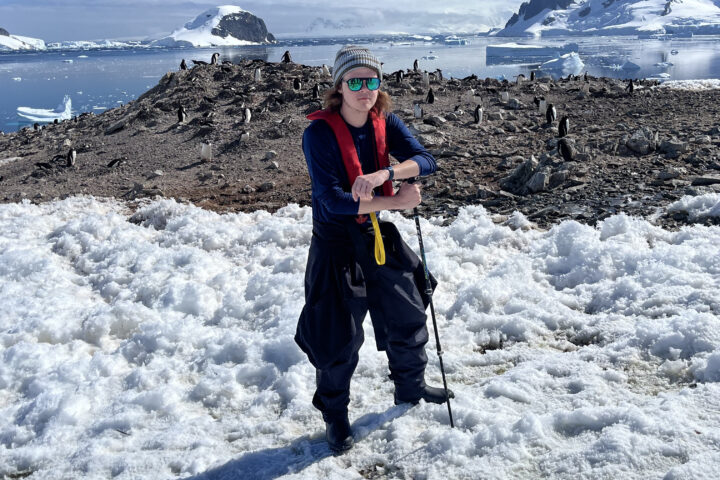 jackson farris in antarctica with penguins in the background