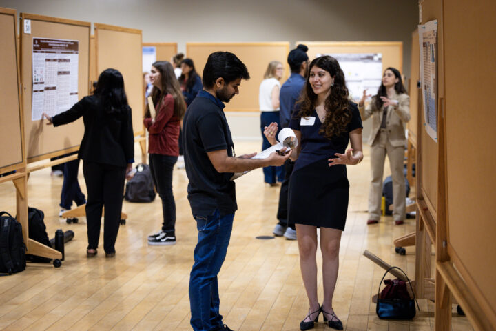 a student participating in a student research week poster presentation