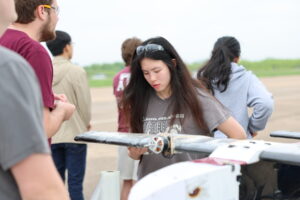 A student inspects an RC plane.