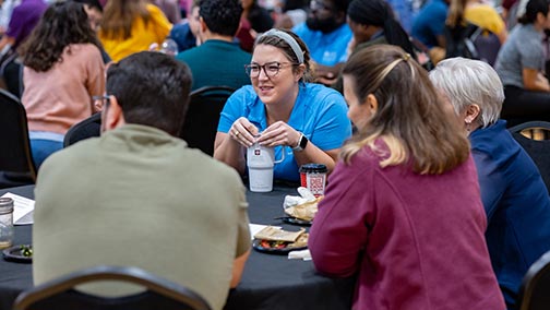Staff members engaging in a roundtable discussion at a division event.