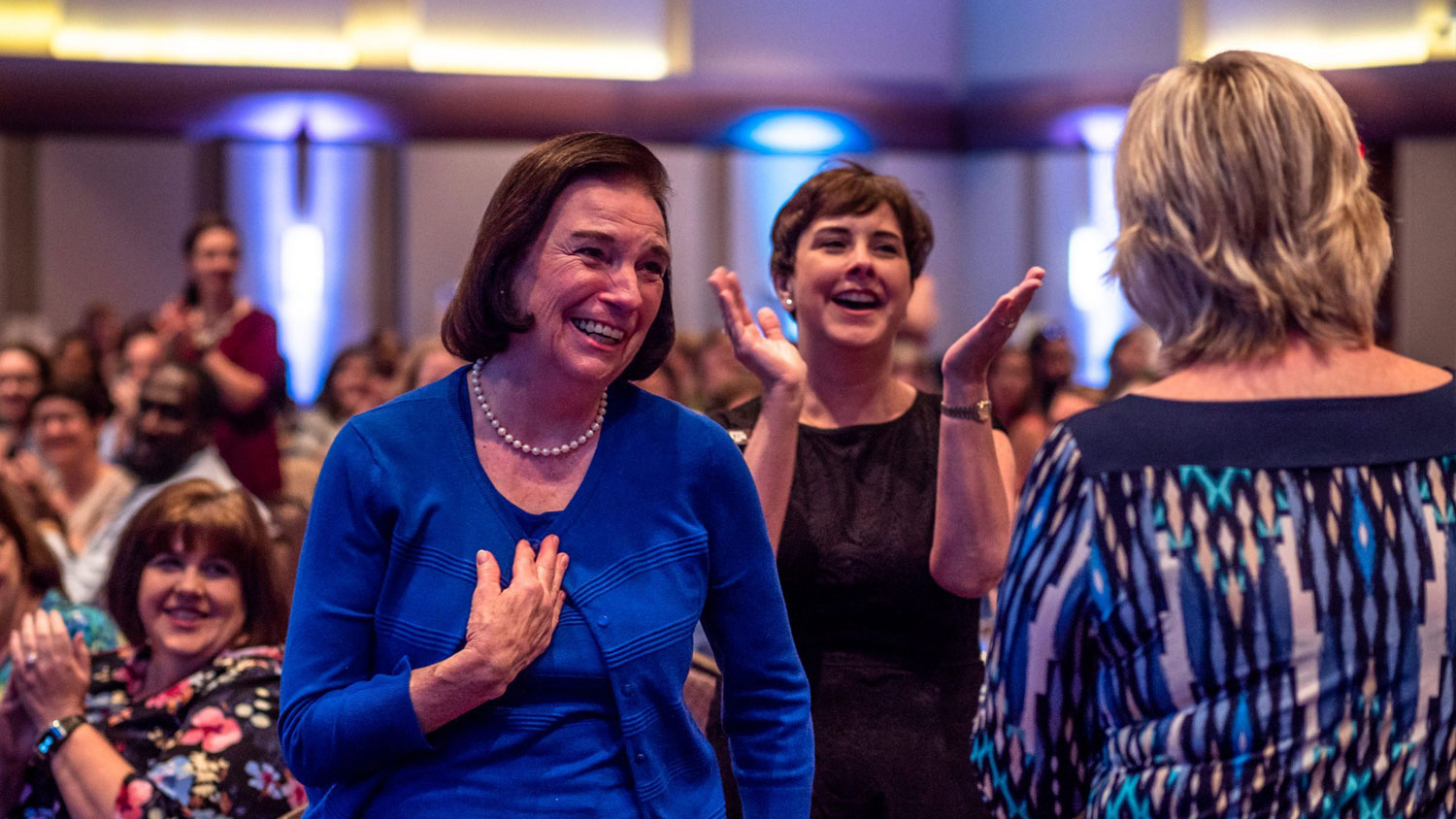 DSA staff member smiling after receiving an award with other staff cheering around her.