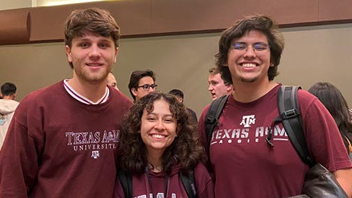 Three students posing for a photo at a DMS event.