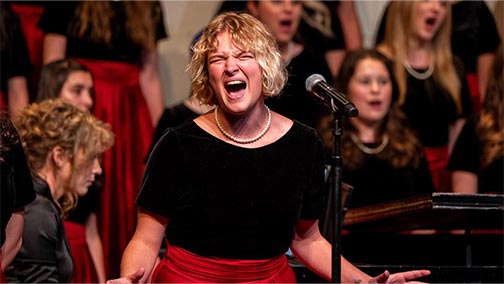 Student singing a solo at a Revelier's concert.