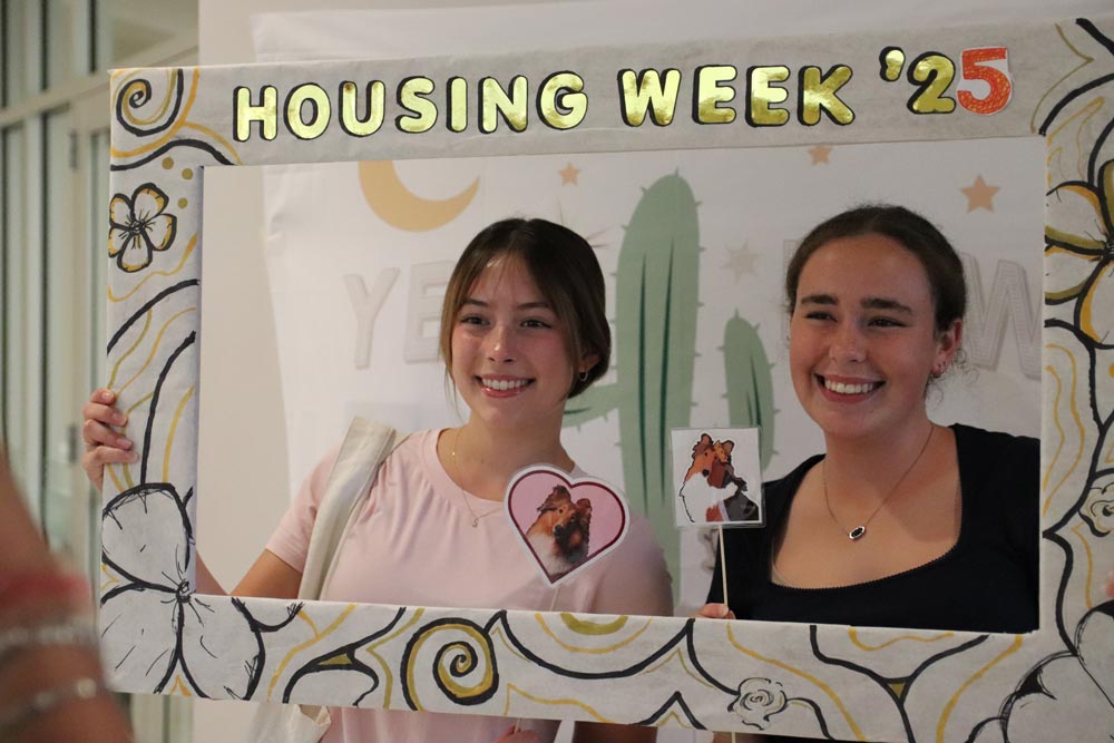 Students holding a frame and posing for a photo during Housing Week
