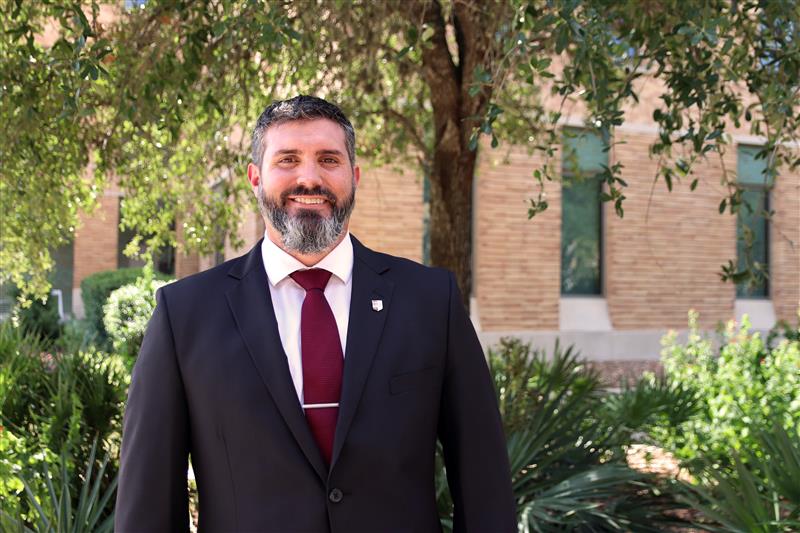 Kyle McCracken smiling for a photo outside of the Student Services Building