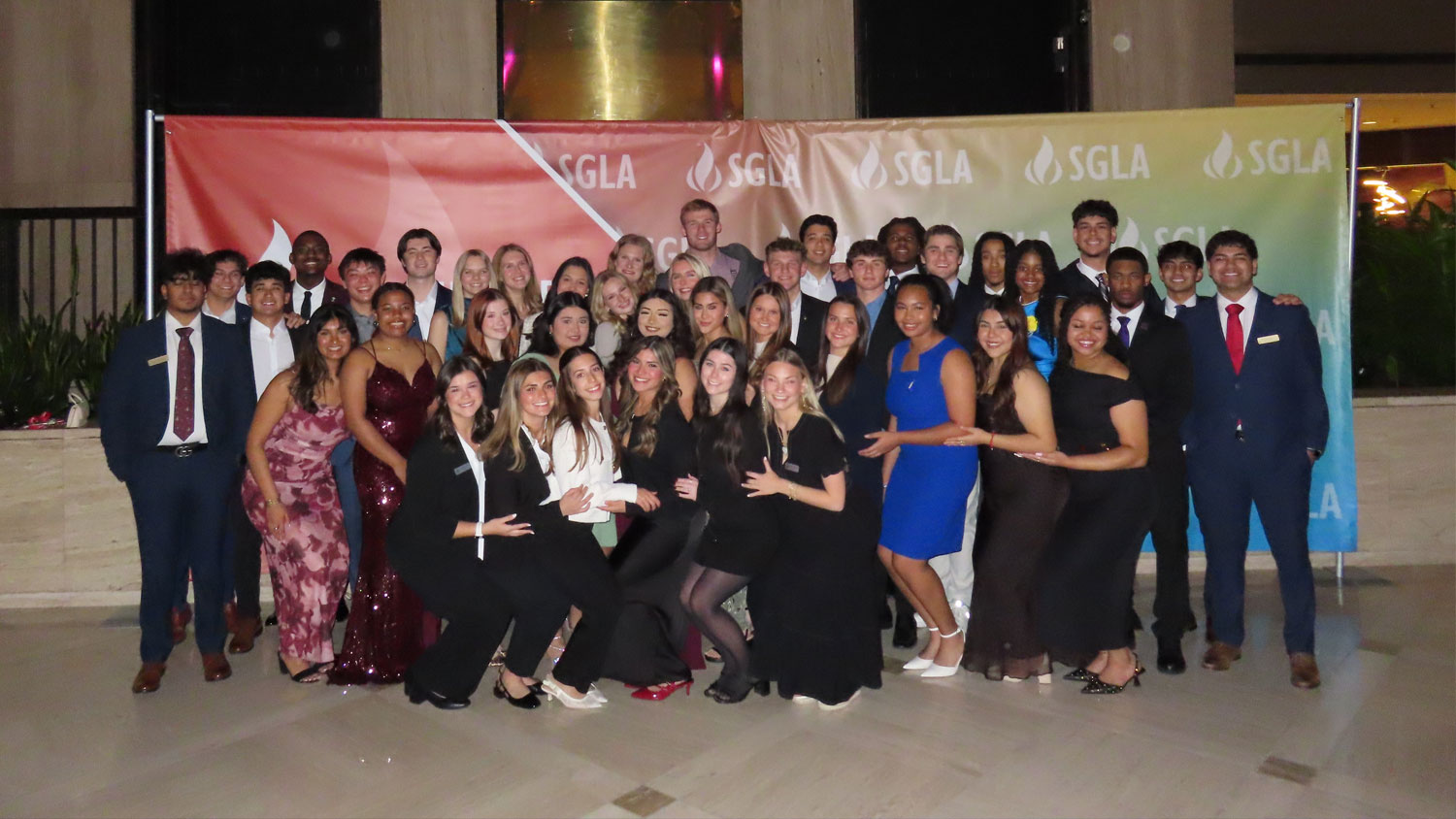 Group of students posing in front of an SGLA backgroup.