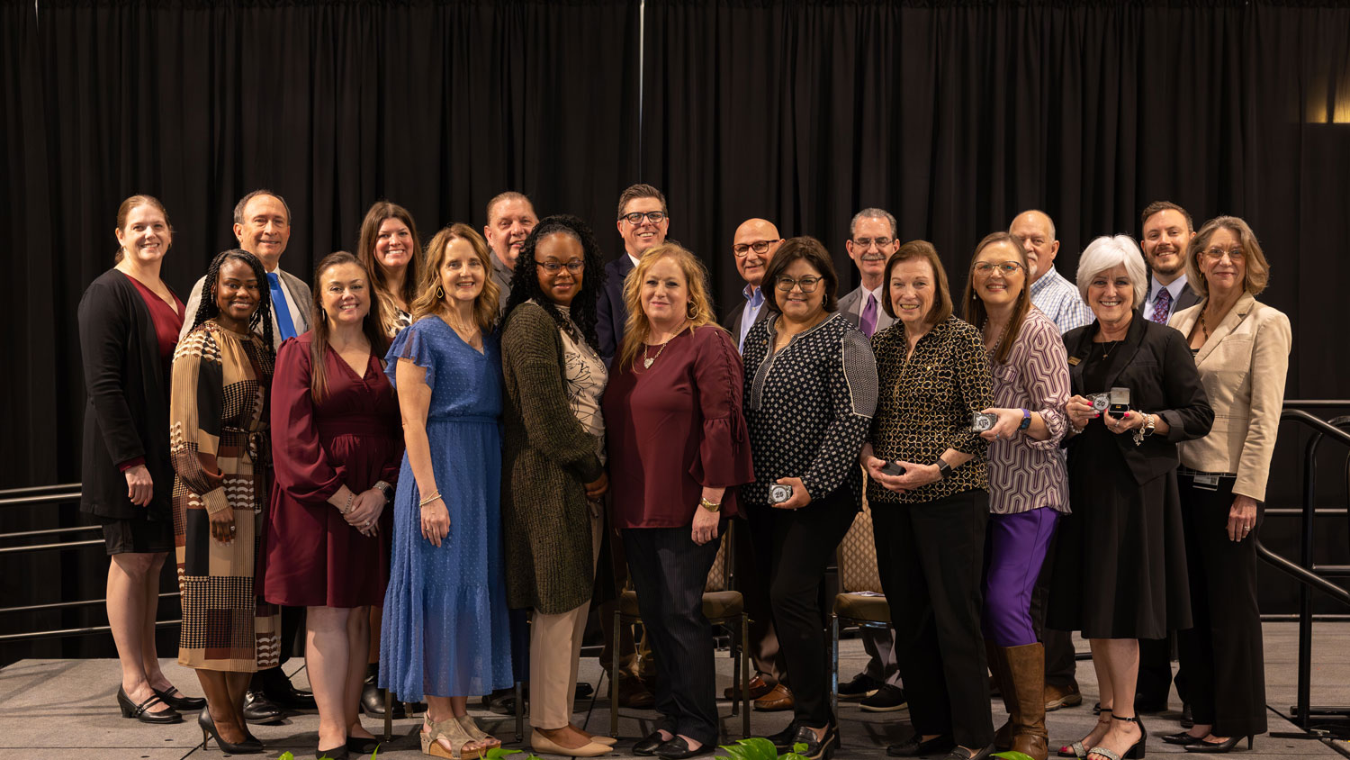 Group of DSA staff members posing for a group photo on stage at the Years of Service celebration.