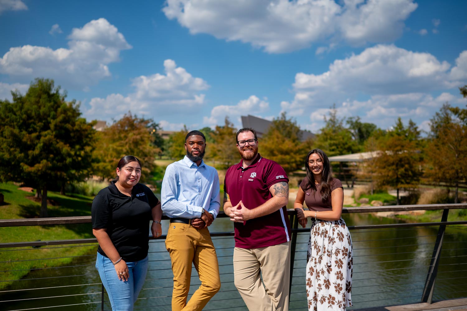 Four SAAHE students posing on the Aggie Park bridge.