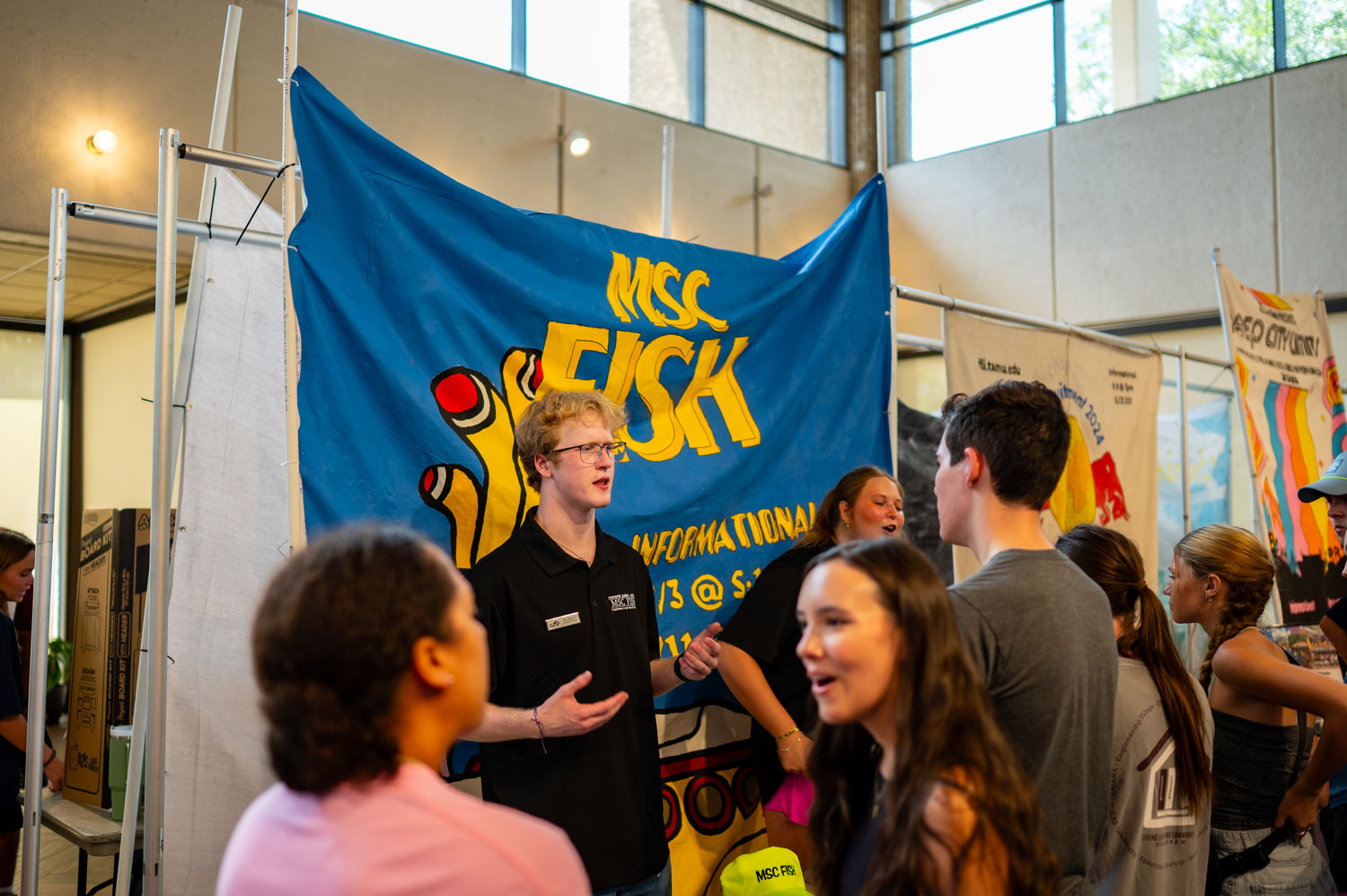 Student at an organization table speaking with an interested student about the org at an MSC Club Crawl event in Rudder Exhibit Hall